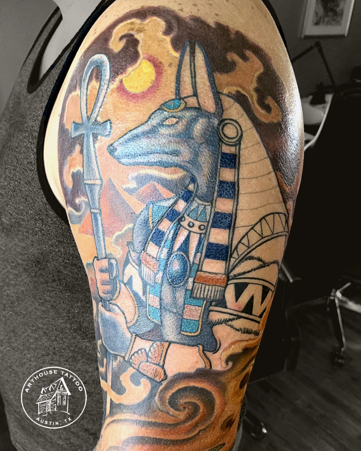 Anubis-inspired tattoo on person's arm.