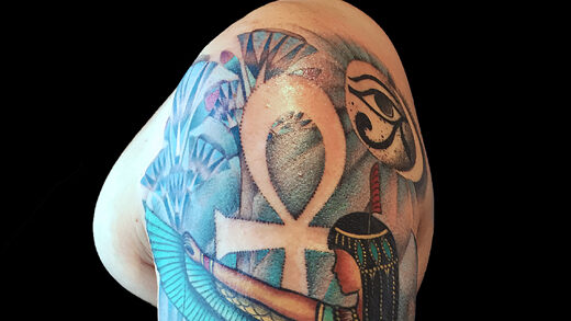 Colorful Egyptian-themed tattoo on arm.