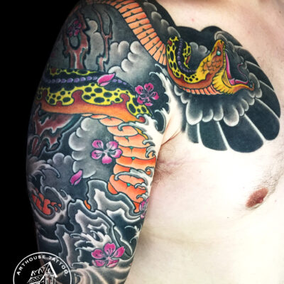 Colorful traditional snake tattoo on arm.