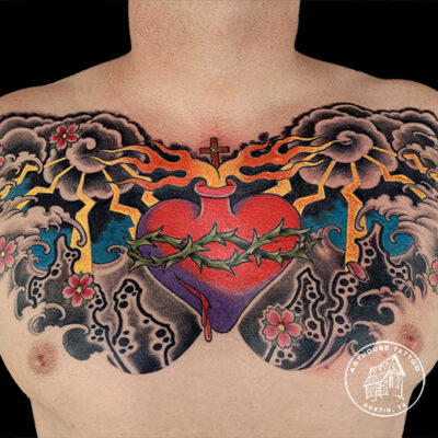 Chest tattoo of sacred heart with clouds and flowers.